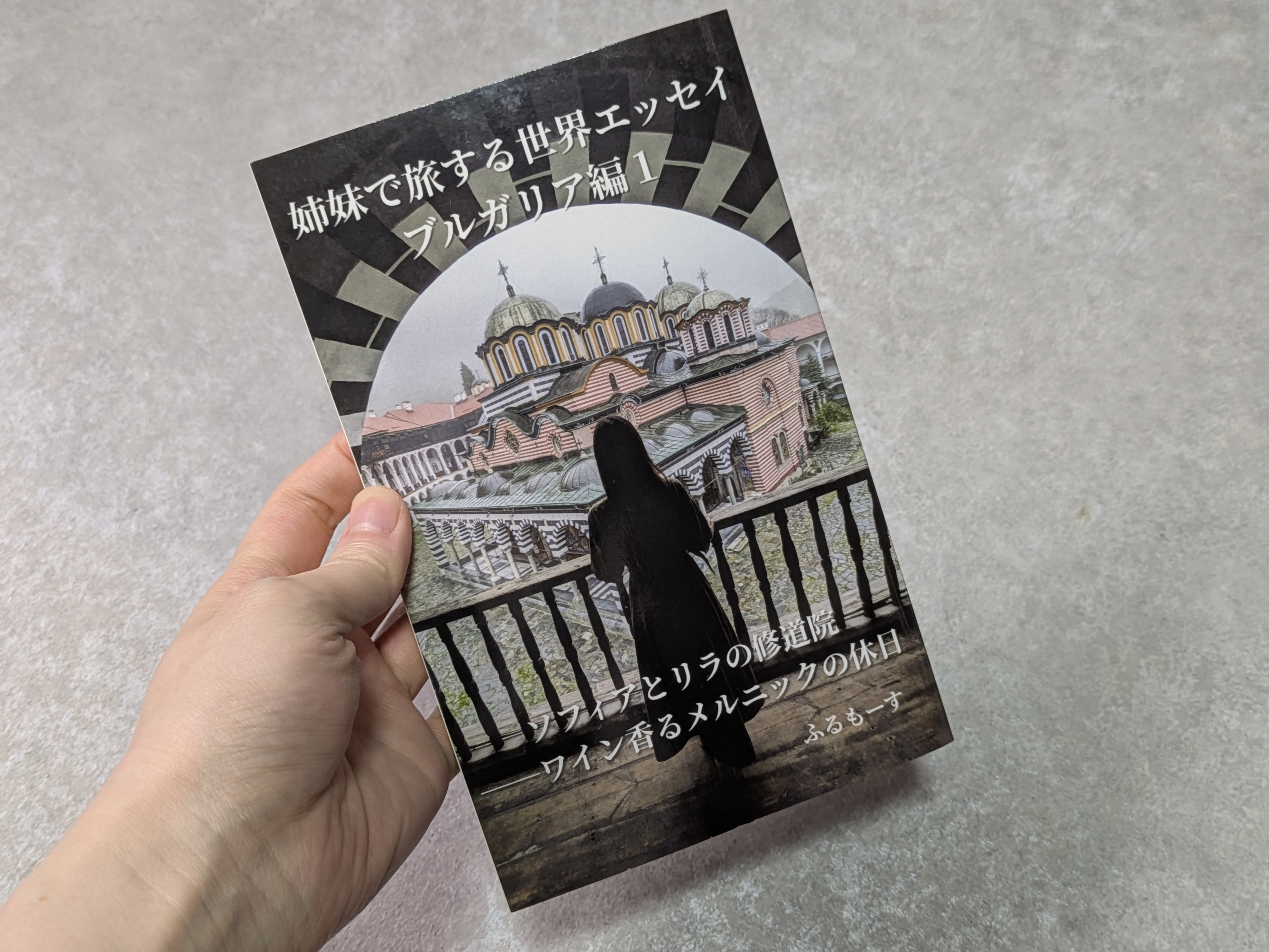 姉妹で旅する世界エッセイブルガリア1を持っている人の手