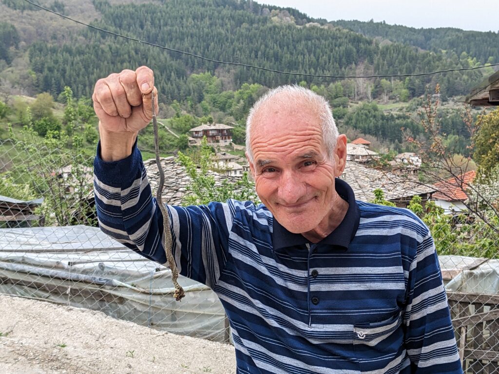 蛇を持った笑顔の老人