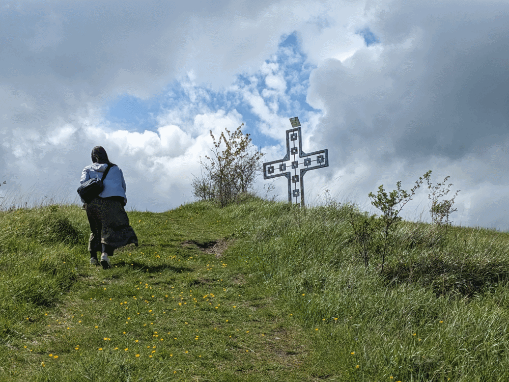 モムチロフツィの丘を登る女性と十字架