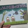 ムシムシ王国のぼうけん絵本を持った手