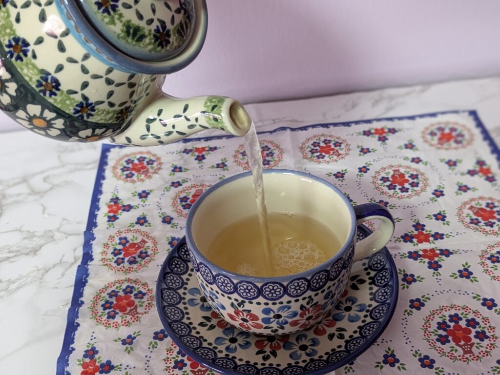 紅茶を注ぐポーリッシュポタリーのポットとティーカップ