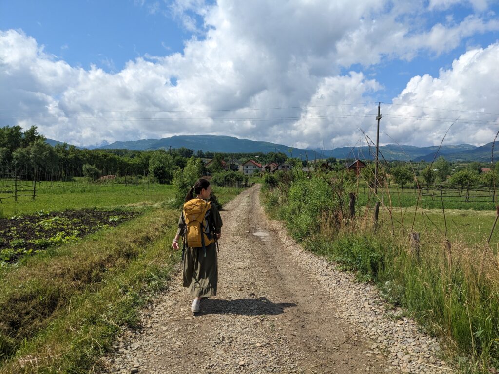 マラムレシュの牧草地を歩く旅人女性の後ろ姿